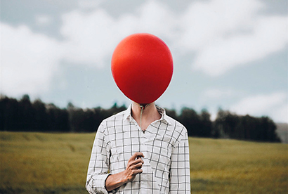 ballon de baudruche figurant une tête devant un buste d'une personne