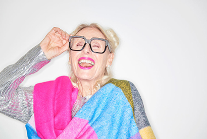 portrait d'une femme âgée bouche grande ouverte (cri) ajustant des lunettes