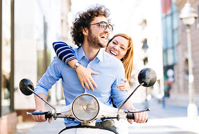 couple de jeunes sans casque de face sur un scooter