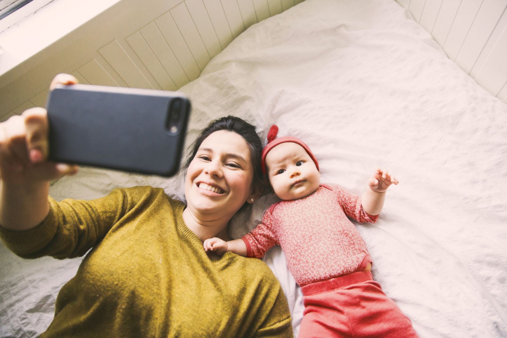 femme et son bébé regardant une tablette en souriant